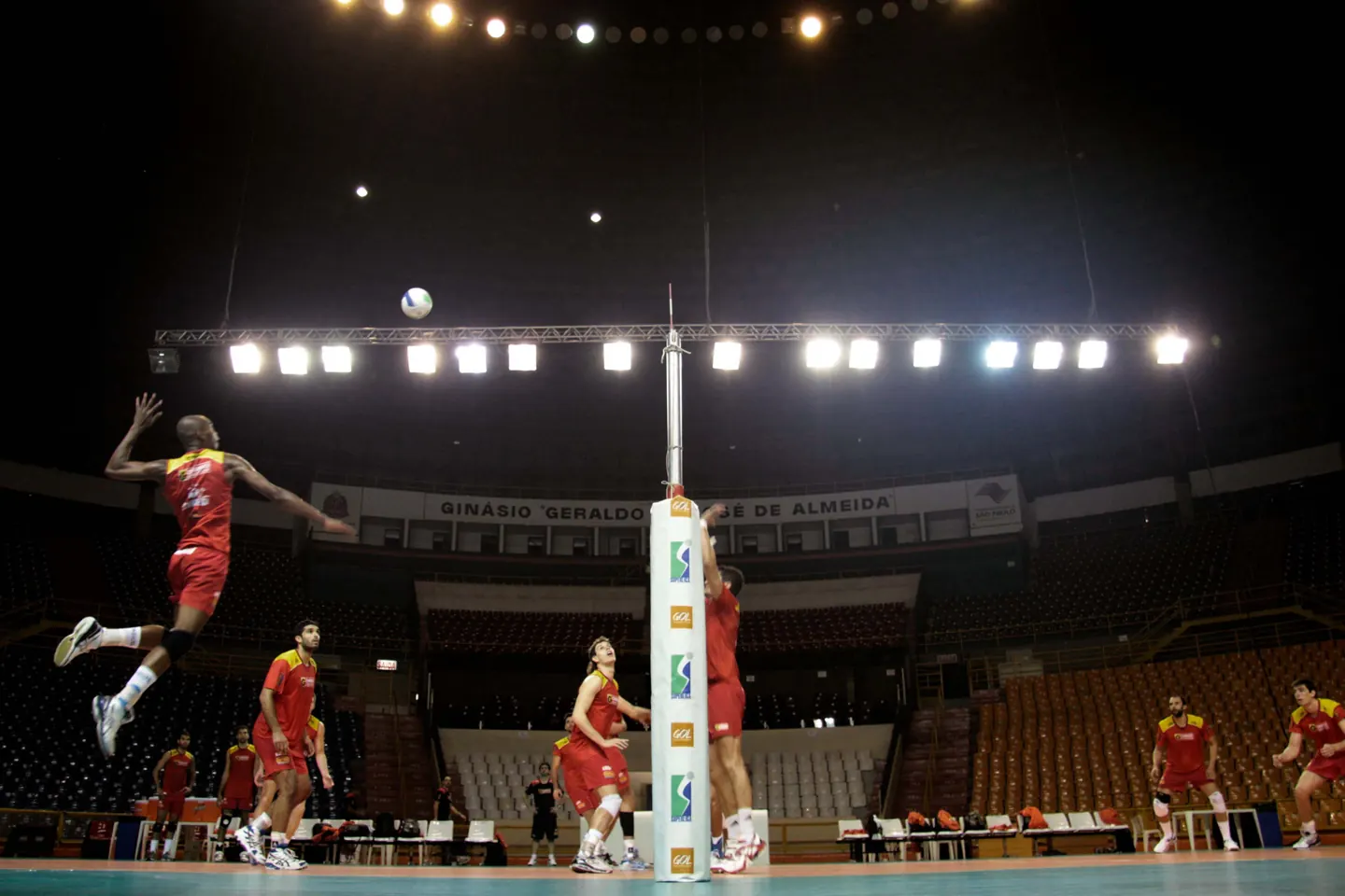 Volleyball players training around the net at Ibirapuera Gymnasium, São Paulo.